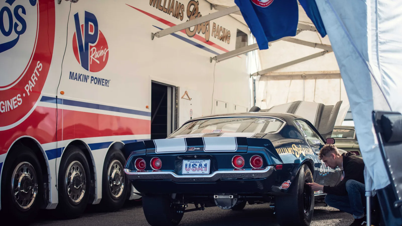 VP Racing support trailer beside a Camaro drag car in the pits